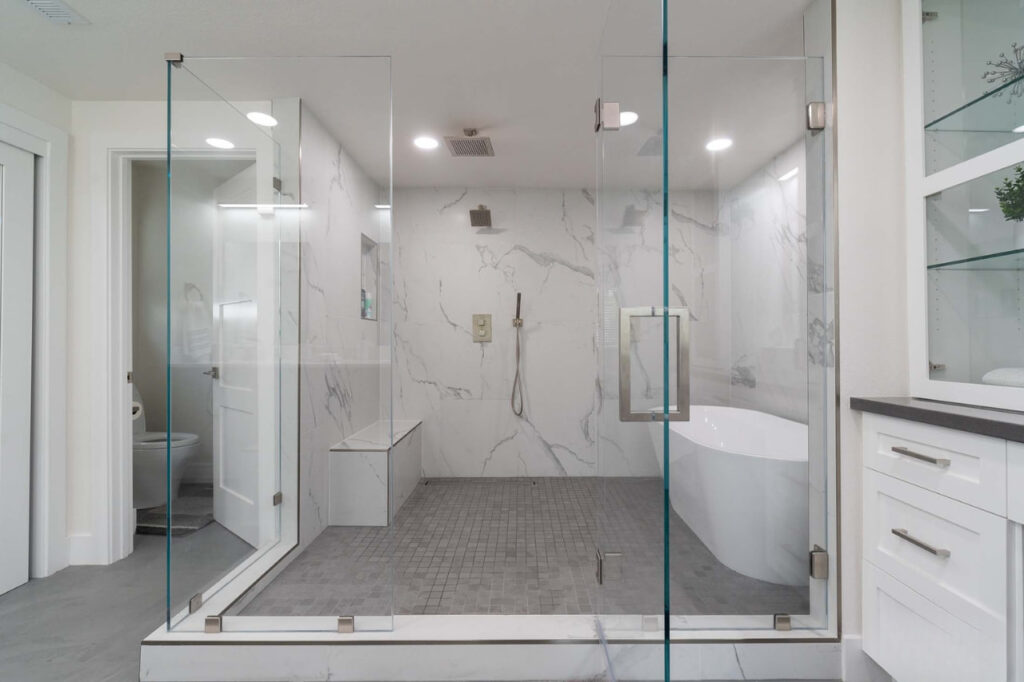 Walk in shower remodel in Los Gatos with frameless glass enclosure, marble tile walls, and modern fixtures