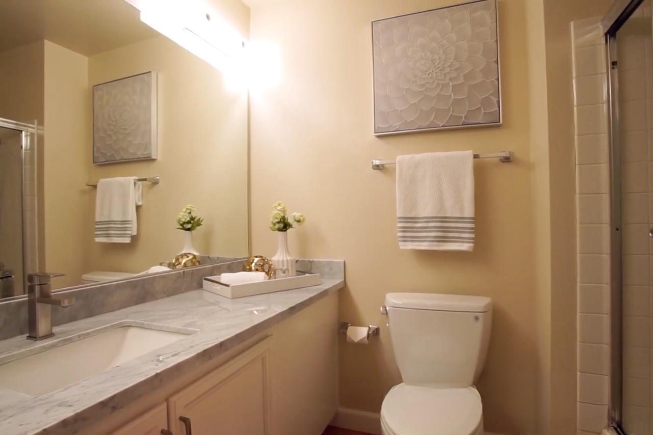 Before bathroom on Central Ave in Mountain View showing existing vanity and shower prior to frameless glass and porcelain slab installation
