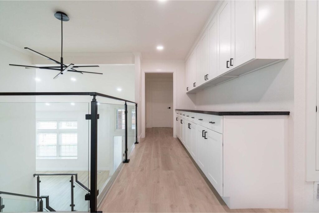 Crossmont Circle home remodel in San Jose with custom cabinetry hallway, white oak hardwood flooring, and matte black glass railing