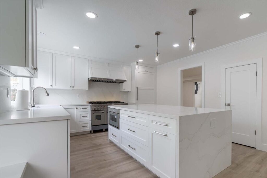Farmhouse kitchen design in San Jose with white cabinetry, minimalist style elements, and modern lighting creating clean aesthetic