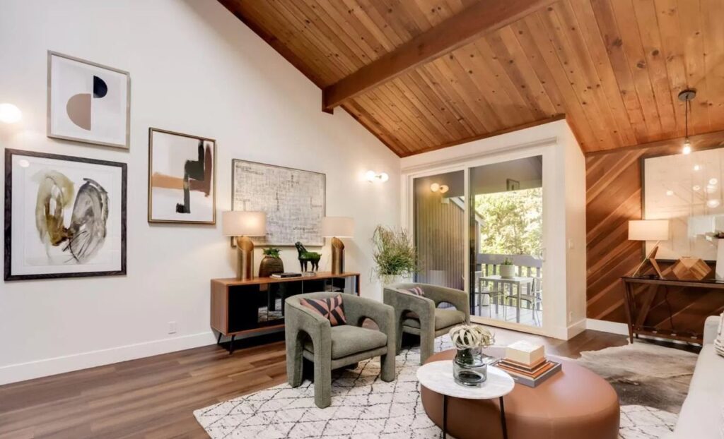 Home addition featuring living space with striking wood accent ceiling, contemporary seating arrangement, abundant natural light, and French doors to outdoor area.