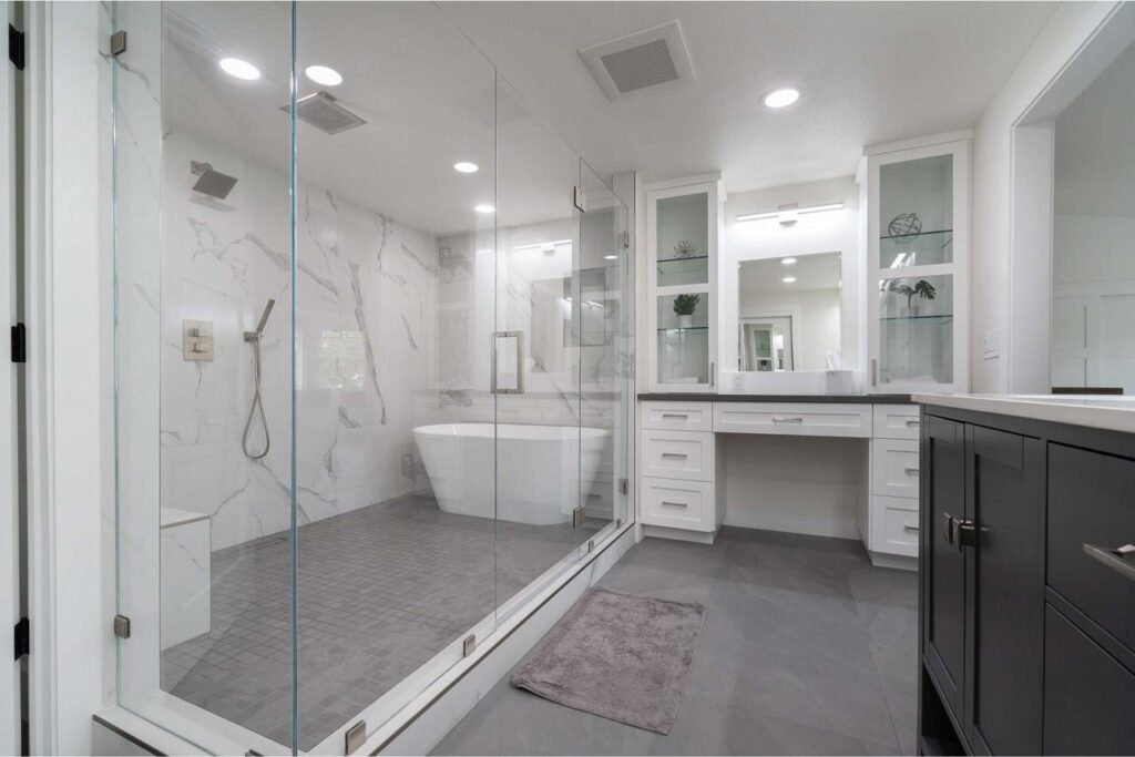 Luxurious kitchen and bathroom renovations showcasing expansive space with elegant freestanding tub, double floating vanity with LED vanity lighting, and frameless glass shower.