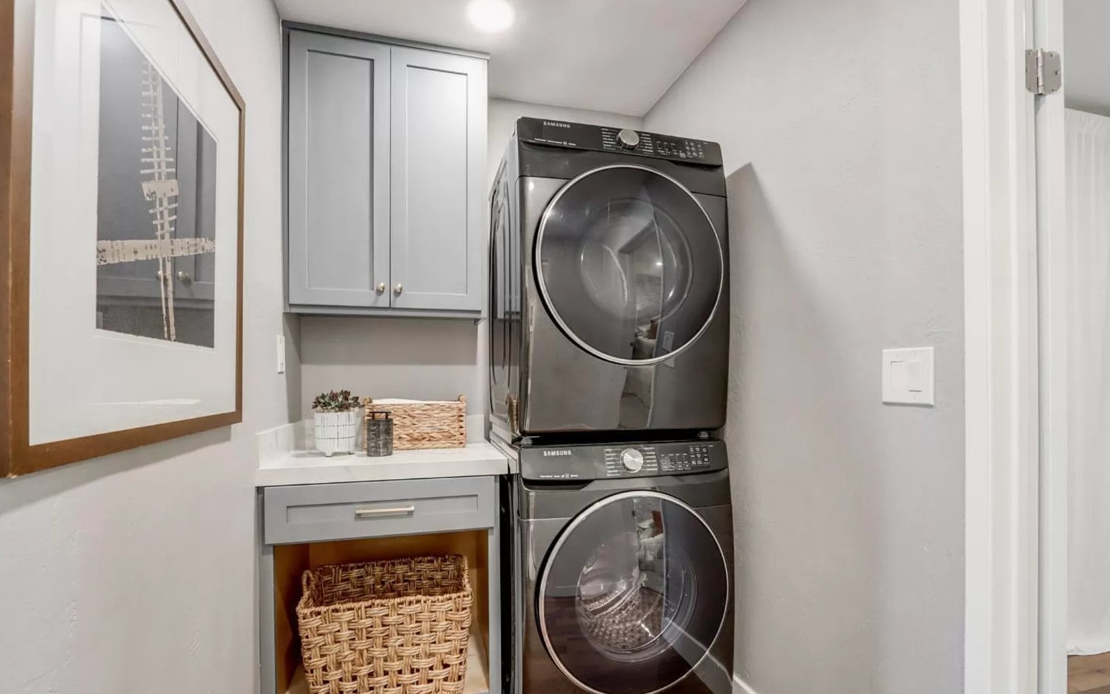Central Ave laundry room in Mountain View with custom cabinetry, stacked washer and dryer, and efficient storage solutions throughout
