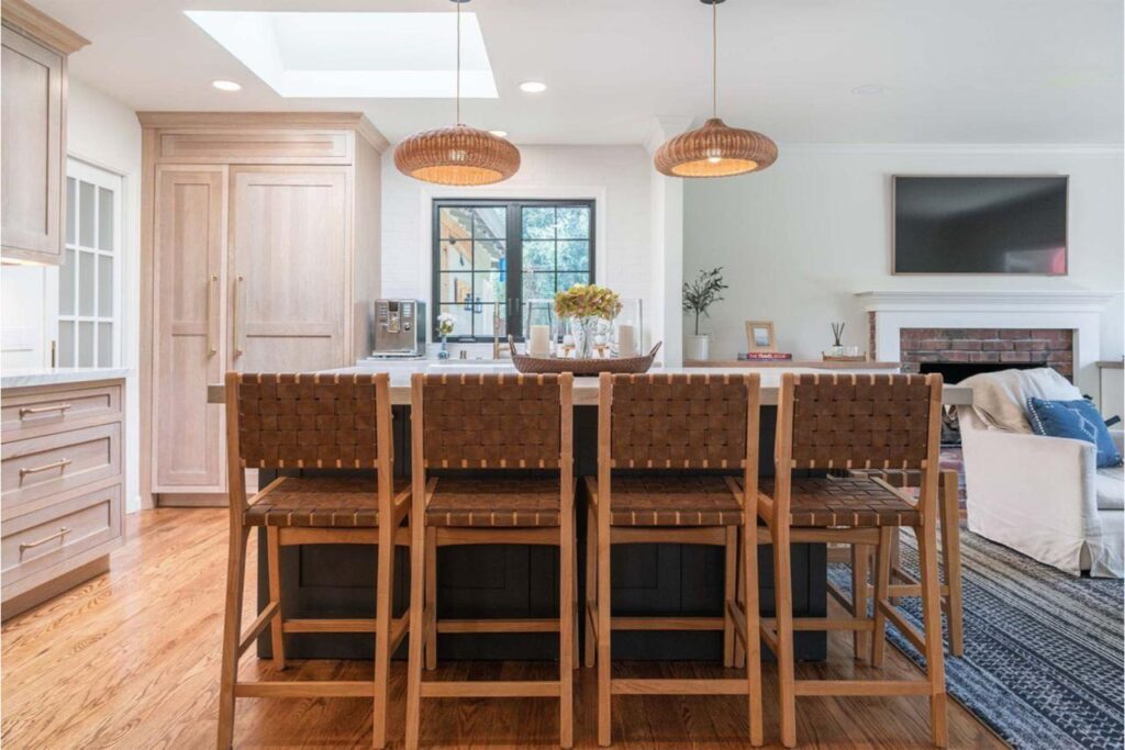 Kitchen and bath remodeling expertise in this design-build project featuring warm wood cabinetry with dark granite countertops and comfortable bar seating area.