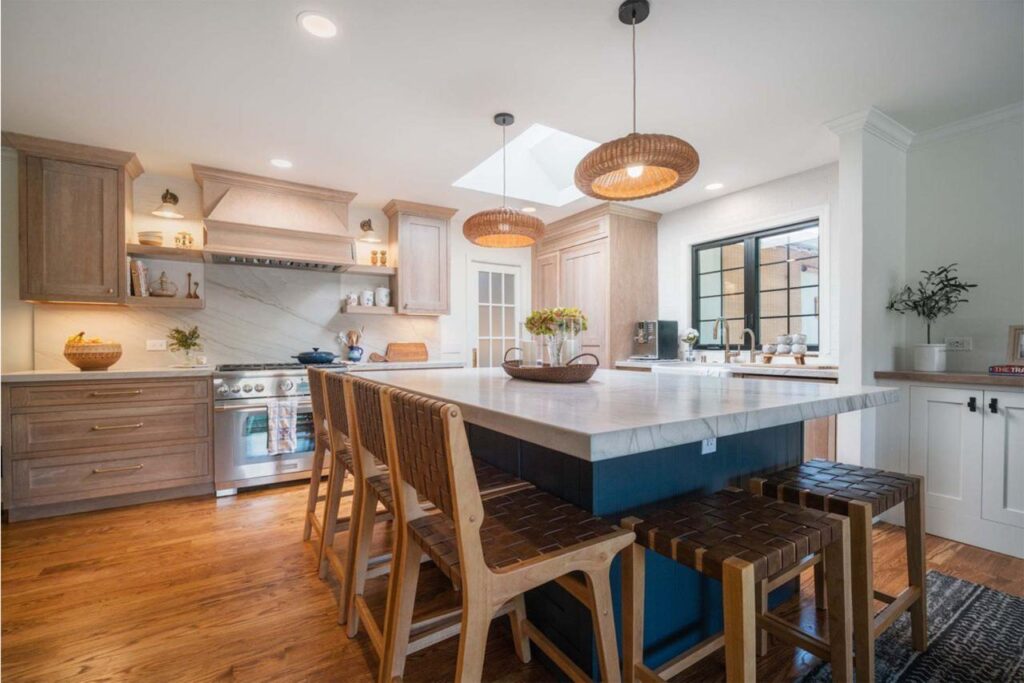 Shulman Ave home remodel kitchen featuring custom maple cabinetry, natural quartzite countertops, floating shelves, and open concept flow to dining area