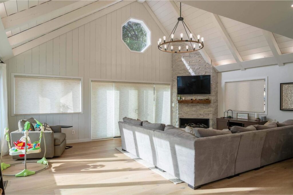 Los Gatos living room on Vista Del Mar with vaulted shiplap ceiling, stone fireplace surround, modern lighting, and engineered white oak flooring