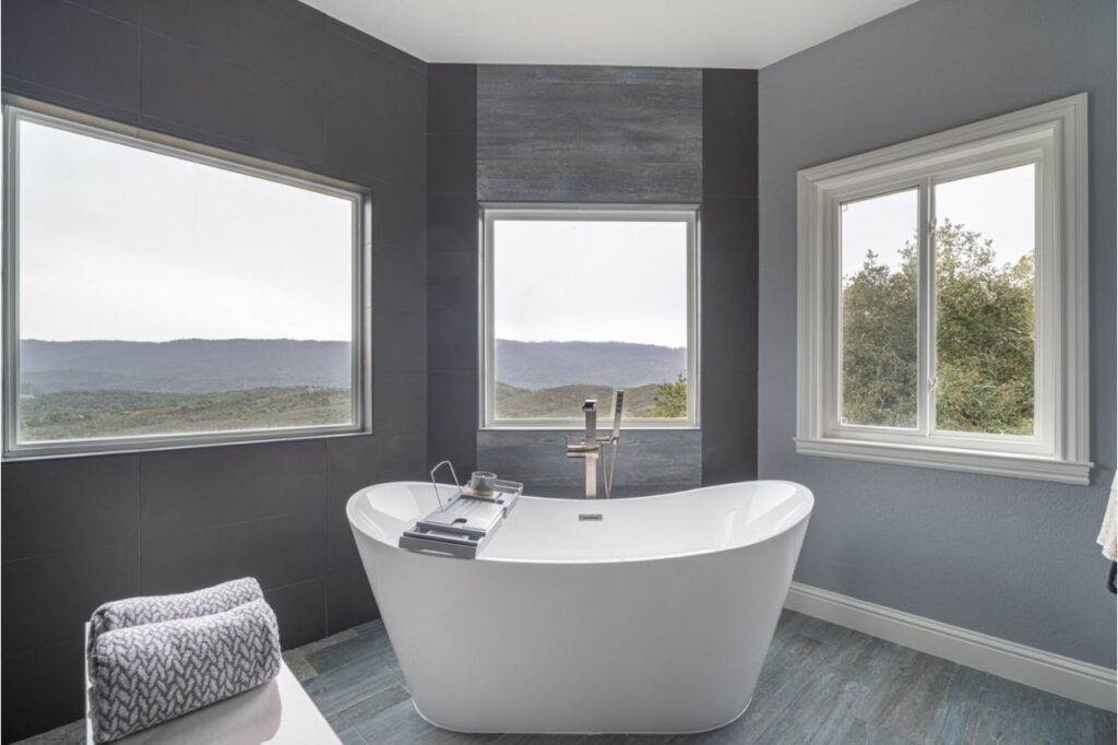 Modern bath remodel in Los Gatos showcasing freestanding tub with mountain views and contemporary dark tile surround