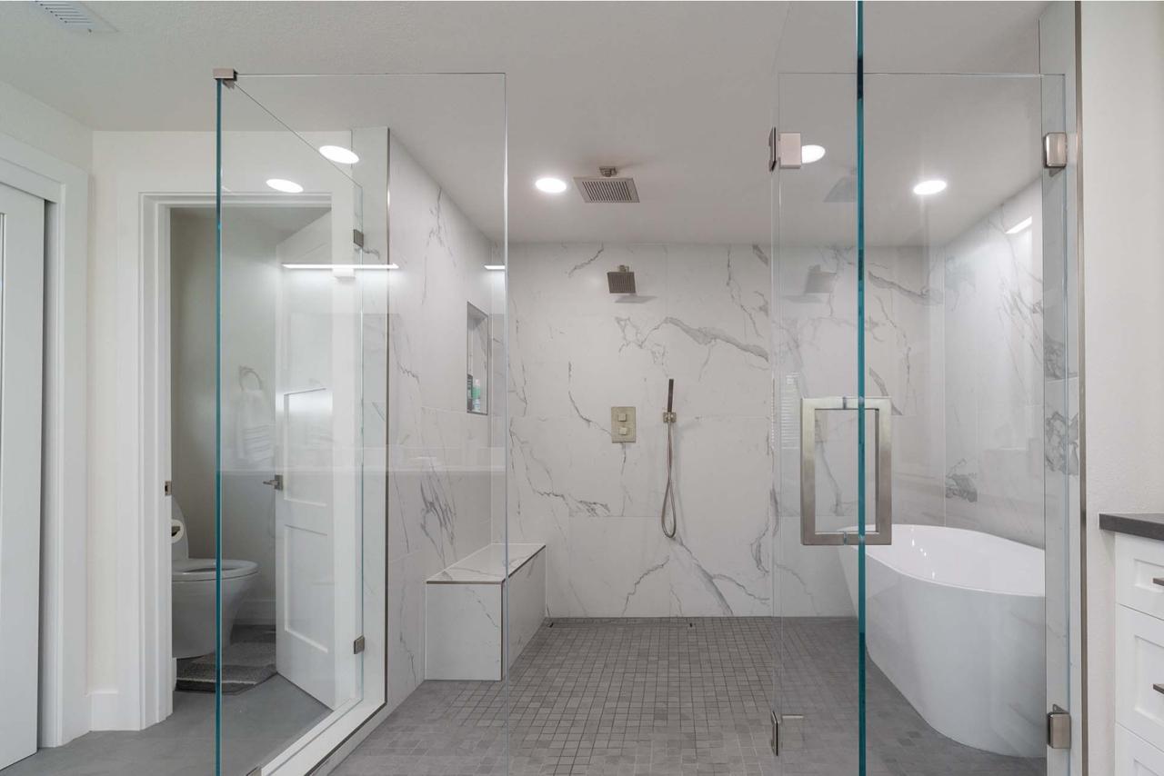 Crossmont Circle primary wet room in San Jose featuring freestanding tub, frameless glass enclosure, dual rain heads, and built-in bench seating